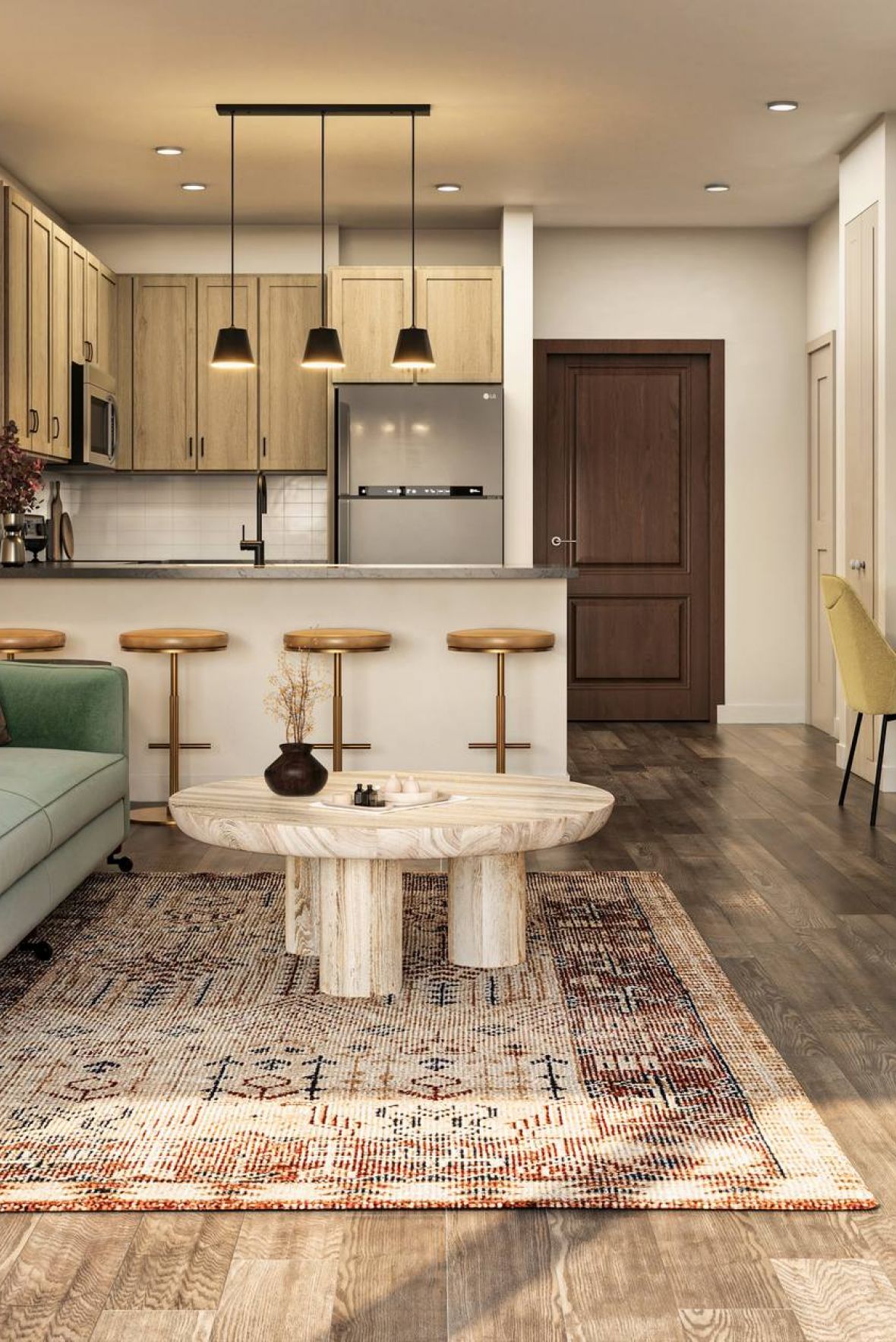 Modern living room with green sofa, round coffee table, and kitchen with bar stools in the background at Harlow apartments.